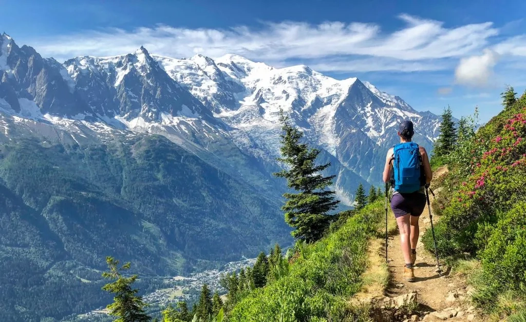 Paysage de montagne dans Préalpes avec un groupe de randonneurs montant une pente avec des bâtons de marche.